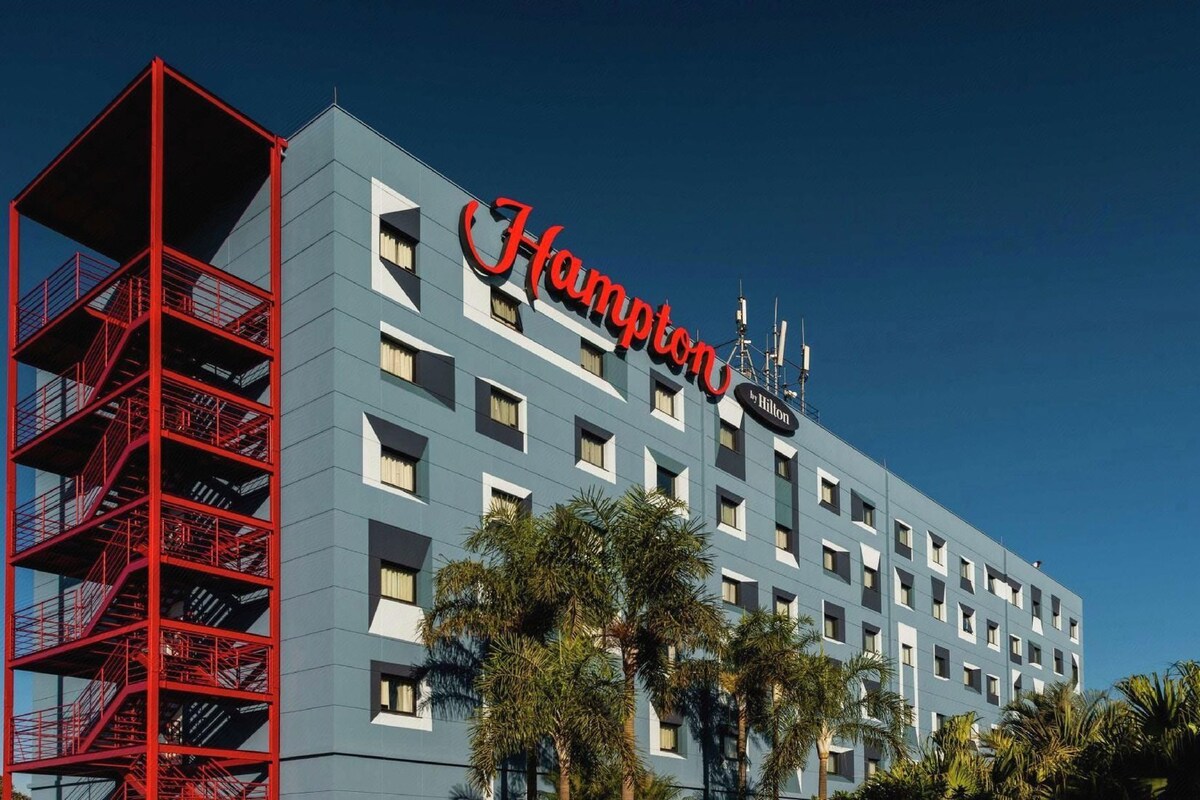 A hotel building with a prominent red sign and a red fire escape.