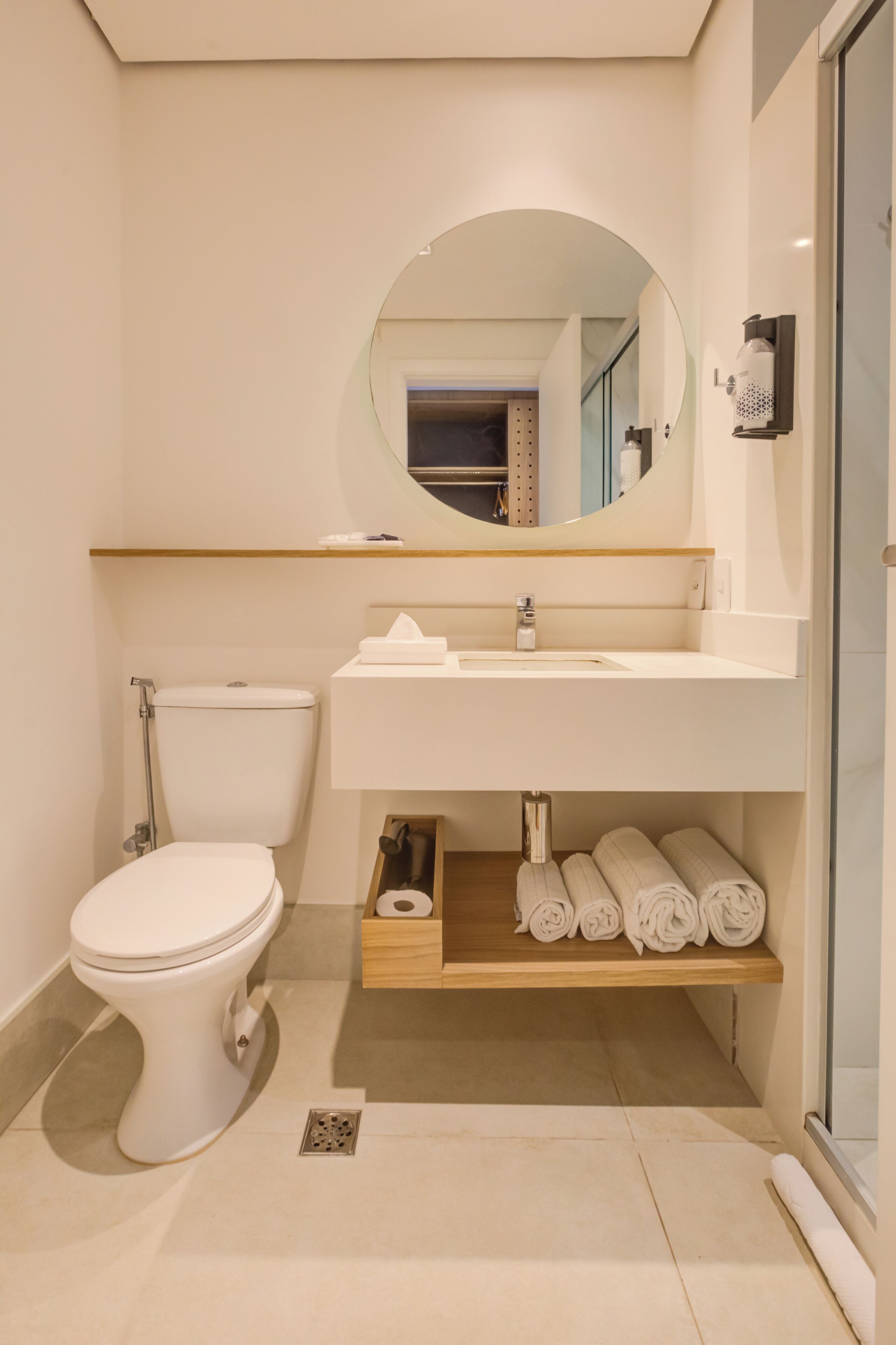 Un bagno moderno con servizi igienici, lavandino, specchio e spazio per asciugamani.