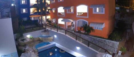 Una piscina al aire libre, sillones reclinables de piscina