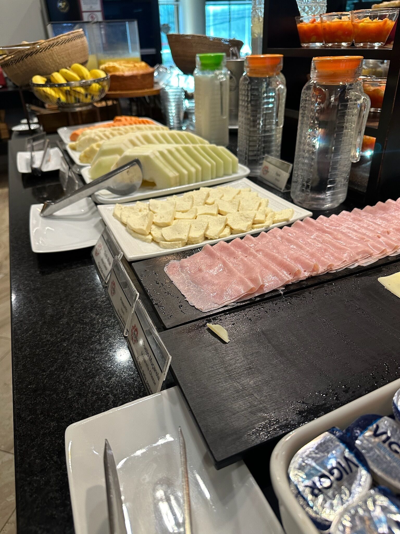 Un buffet con diverse pietanze, tra cui salumi, formaggi e altri piatti.
