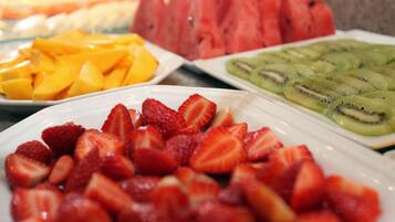 Variedad de frutas frescas como fresas, mangos, sandía y kiwi a la vista.