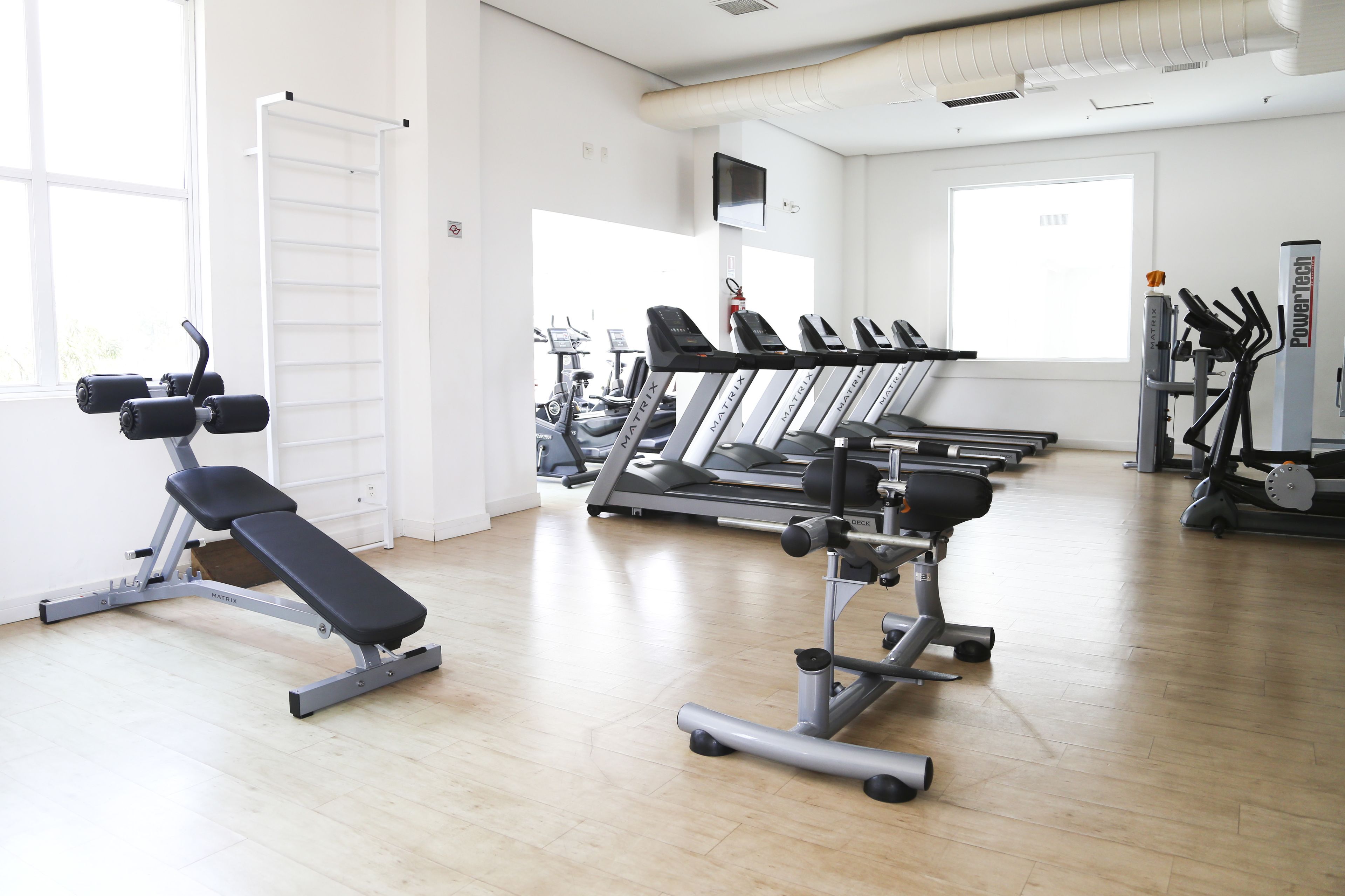 A gym with treadmills, a bench press, and weight machines.