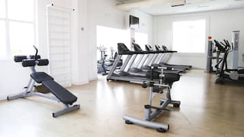 A gym with treadmills, a bench press, and weight machines.