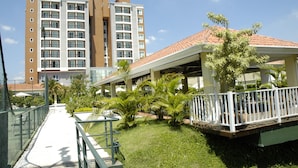 A hotel with a covered outdoor area, a pathway, and a pool.