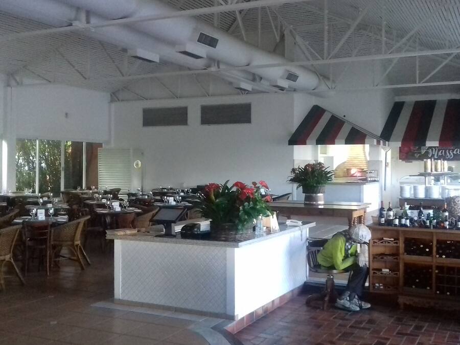 A spacious restaurant with high ceilings, a central bar area, and a seating arrangement that includes both tables and chairs.