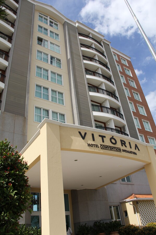 A multi-story hotel with balconies, a sign reading "VITORIA HOTEL CONVENTION INDALETURA," and a clear sky.