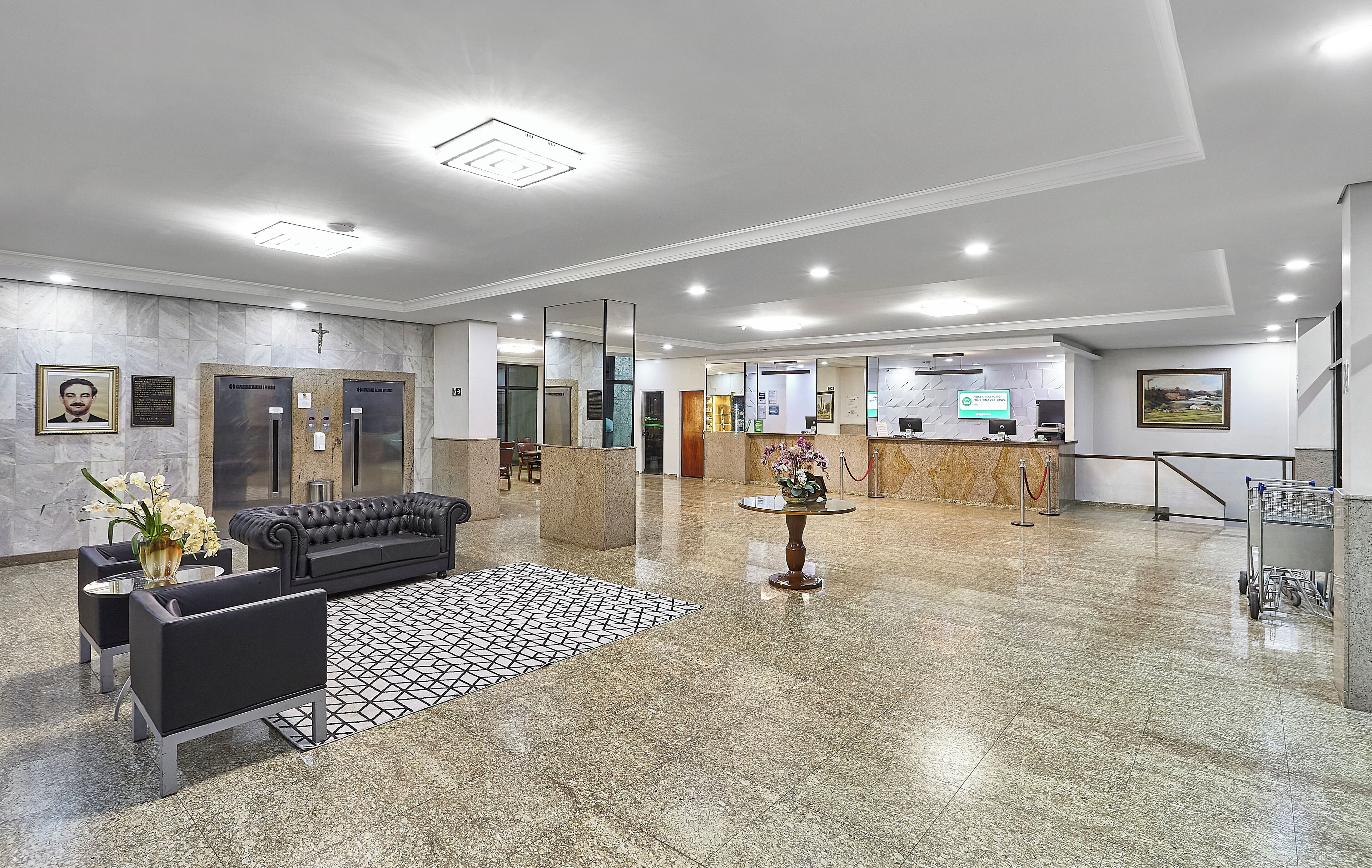Un vestíbulo moderno con mostrador de recepción, zona de estar y ascensores.