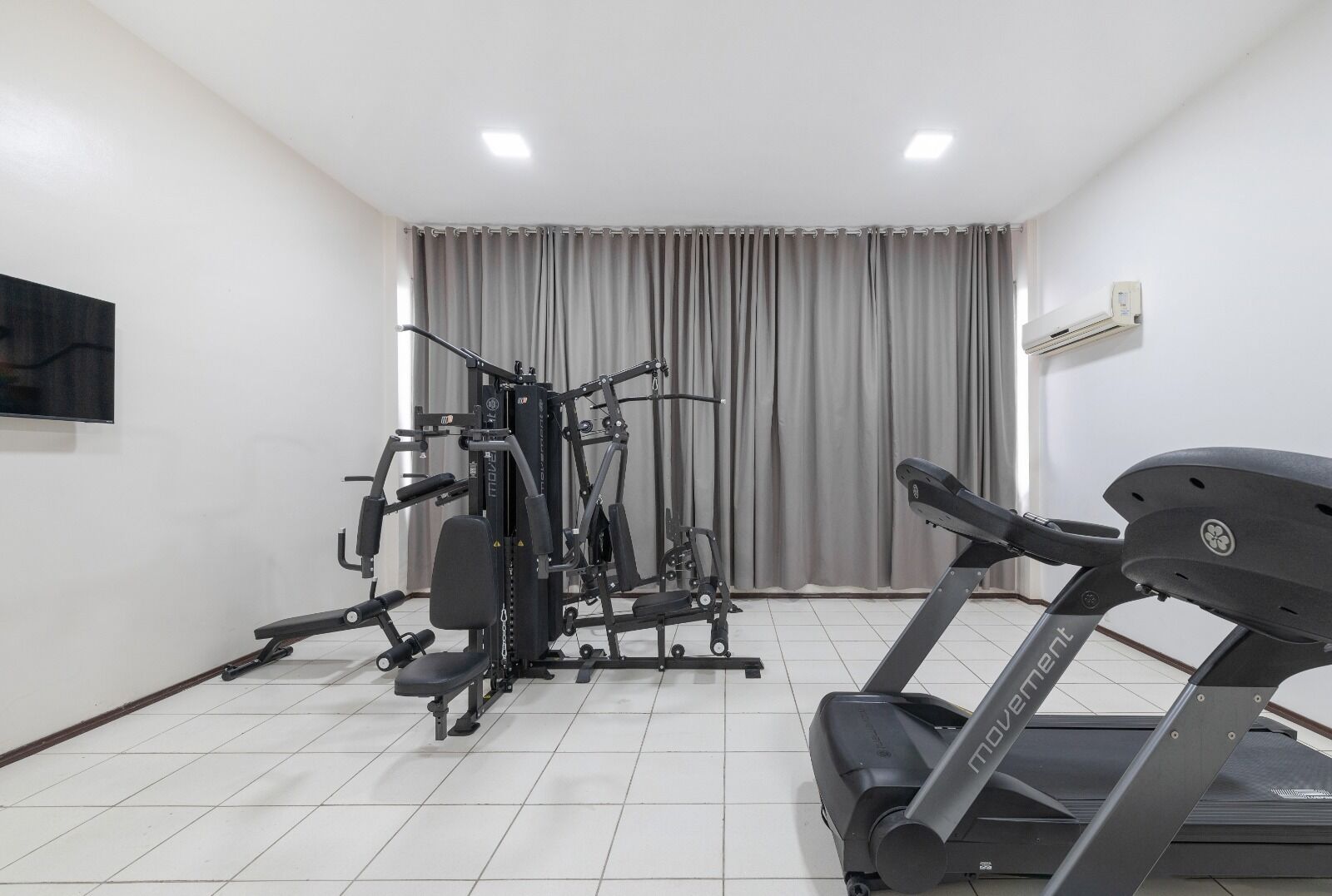 A gym with a treadmill and weight machines.