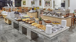 Montaje de bufé con diversos alimentos y una estación de café.