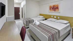 Habitación de hotel con dos camas, televisión, cabecero de madera y un cuadro en la pared.