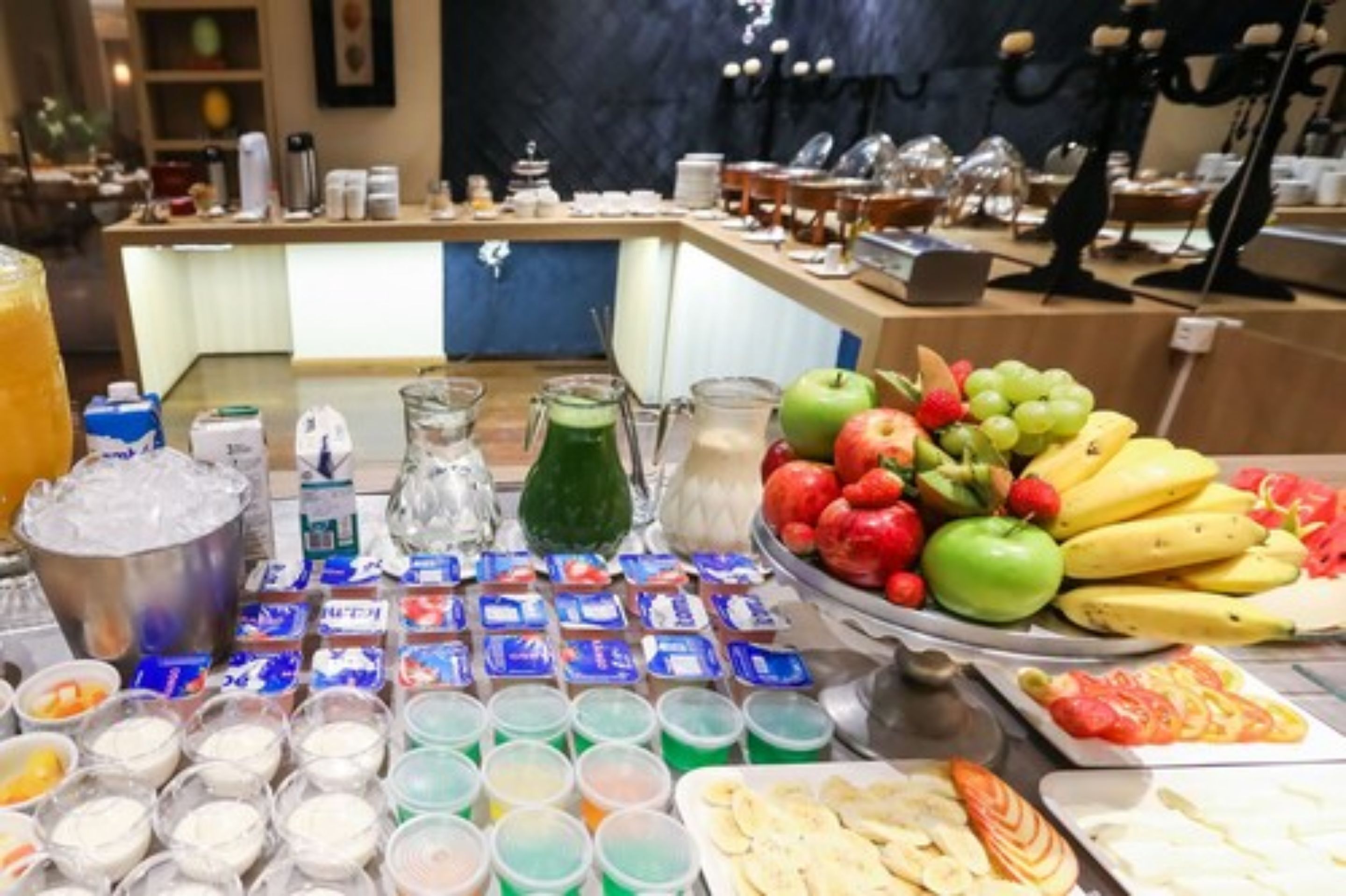 A buffet with various food items including fruits, dairy products, and beverages.