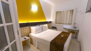 Ein Hotelzimmer mit einem Bett, einem Nachttisch und einem kleinen Schreibtisch mit Stuhl.