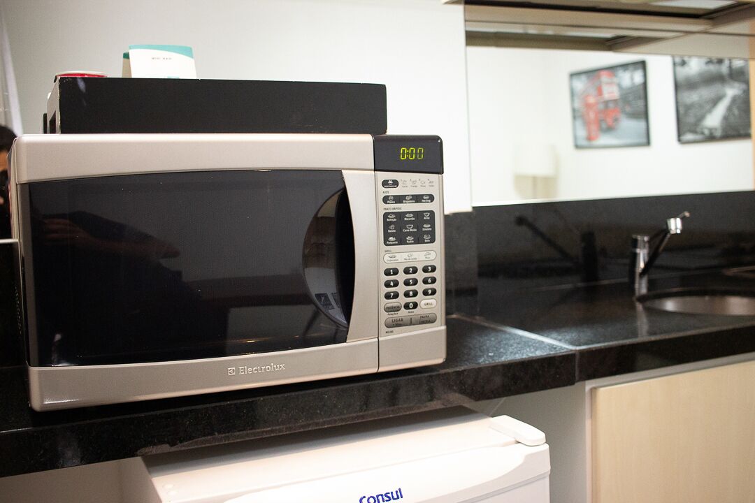 Un forno a microonde su un piano di lavoro in cucina, con display digitale.