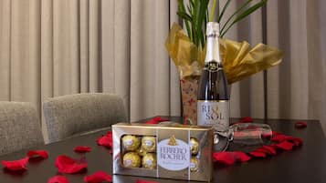 Una mesa con una botella de champán RIO SOL, una caja de bombones Ferrero Rocher y una copa.