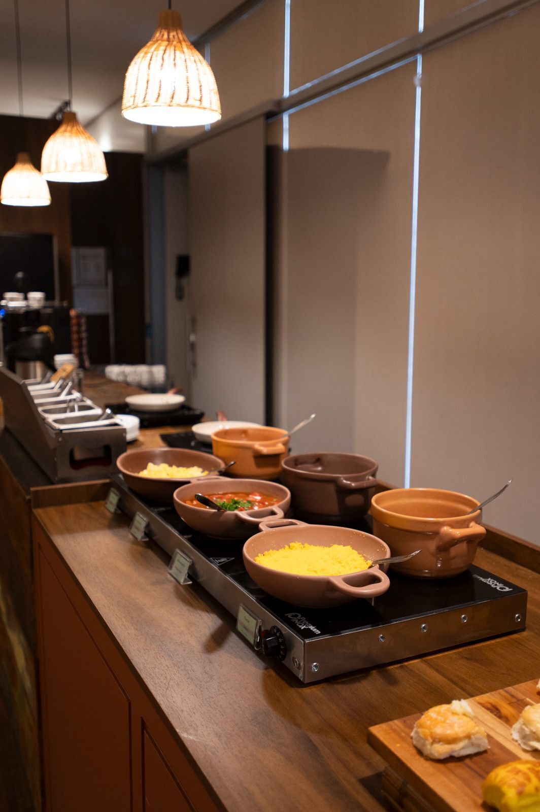 A buffet counter with various dishes in ceramic pots and a toaster.