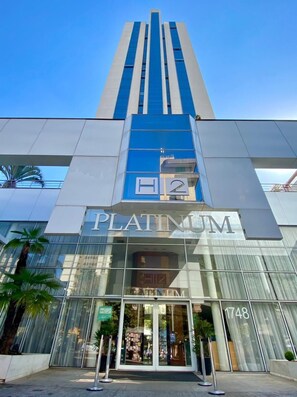 A modern hotel with a prominent 'Platinum' sign, large glass windows, and a clear sky. - H2 Platinum Lourdes (Belo Horizonte)