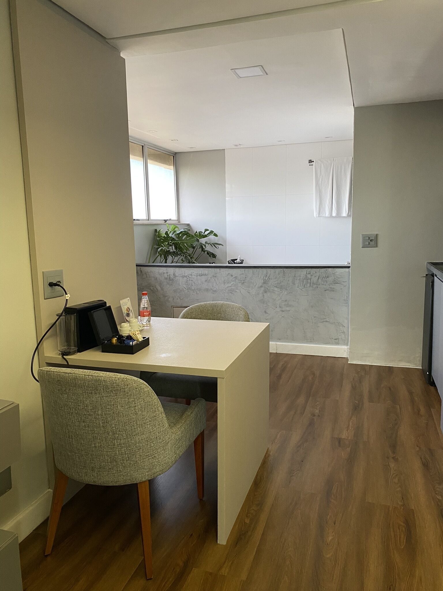 Una habitación de hotel moderna con comedor, una pequeña cocina y vistas a la ciudad.