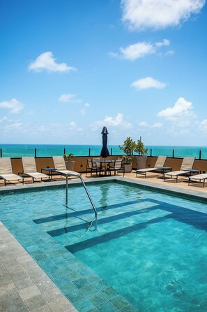 A pool area with lounge chairs and a view of the ocean. - Park Hotel (Recife)