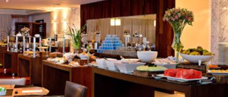 A buffet setup with various food items and a decorative centerpiece.