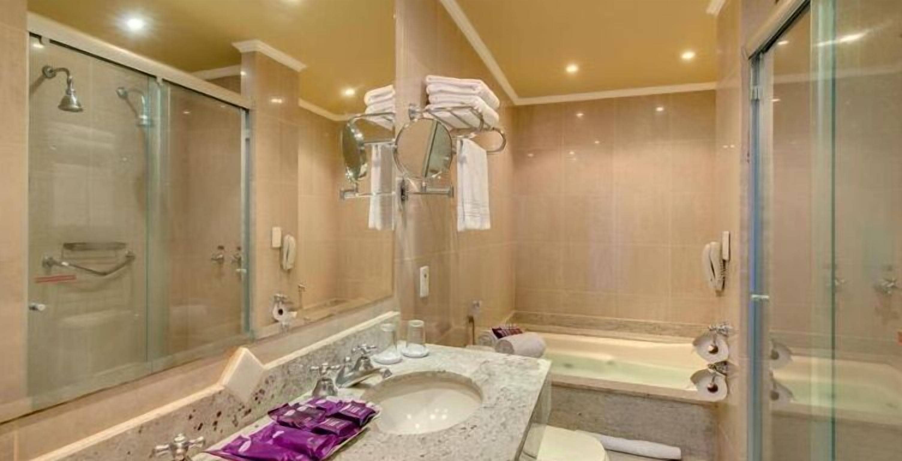 A modern bathroom with a large sink, a bathtub, and a shower area.