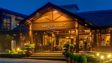 Experience a warm and inviting atmosphere at our resort, featuring a traditional architectural style with a pitched roof and wooden beams.