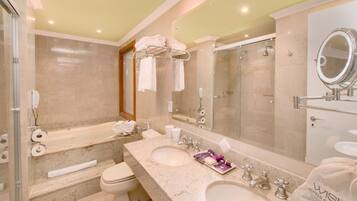 Un baño moderno con lavamanos doble, un espejo grande, cabina de ducha con mampara de cristal y un inodoro.