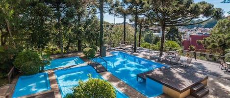 Una piscina cubierta, una piscina al aire libre, tumbonas