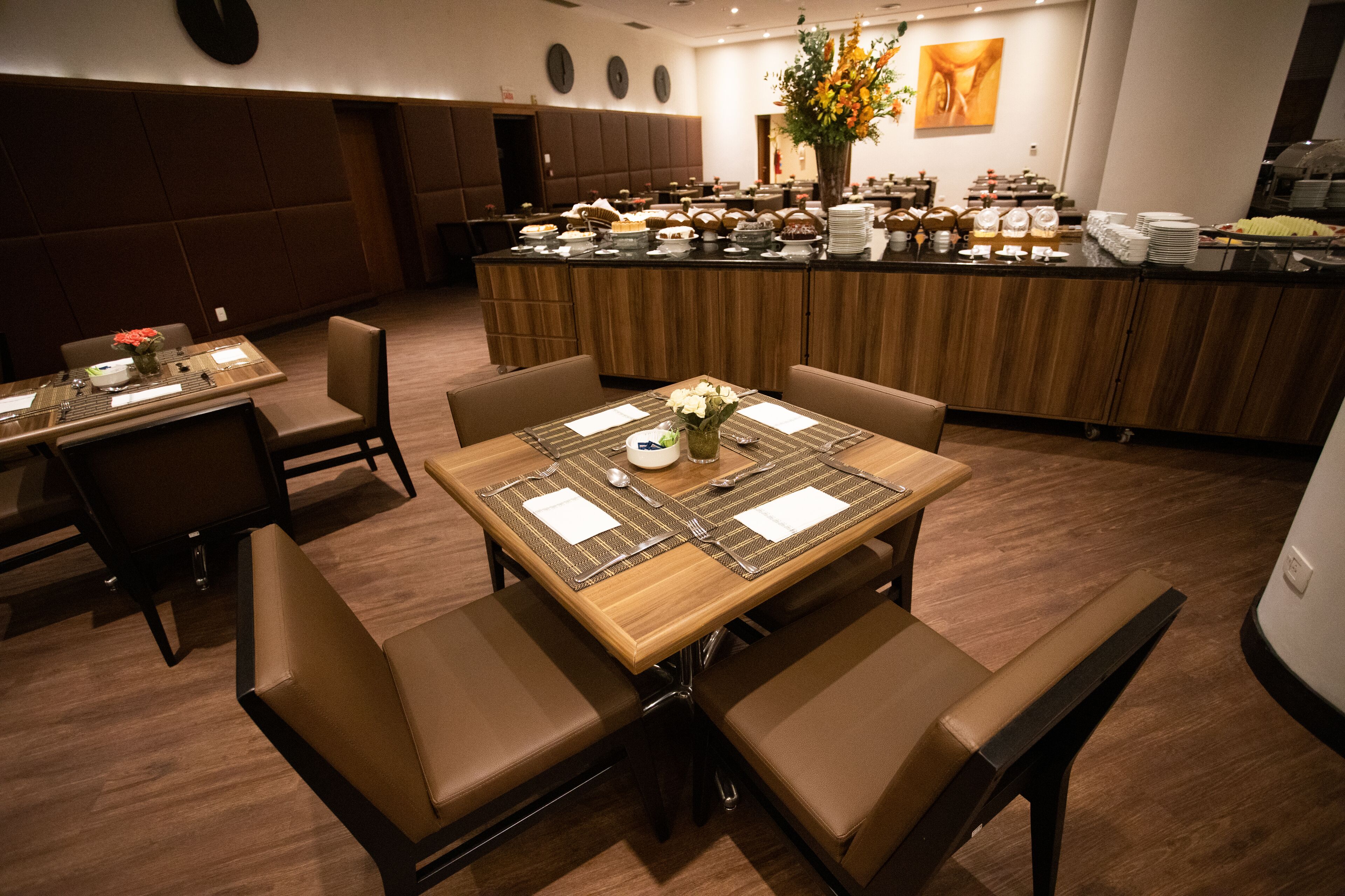 A restaurant with a central dining table, booths, and a buffet area.