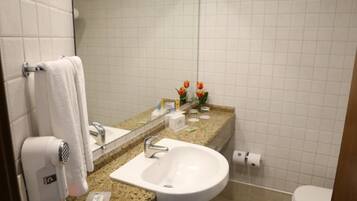 A bathroom with a white sink, a mirror, a towel rack, and a toilet.
