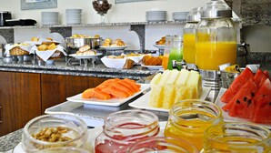 Un bufé de desayuno con diversas opciones de comida y bebidas.