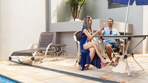 A poolside area with lounge chairs and a table. - Hotel Dan Inn Araraquara By Nacional Inn  (Araraquara)