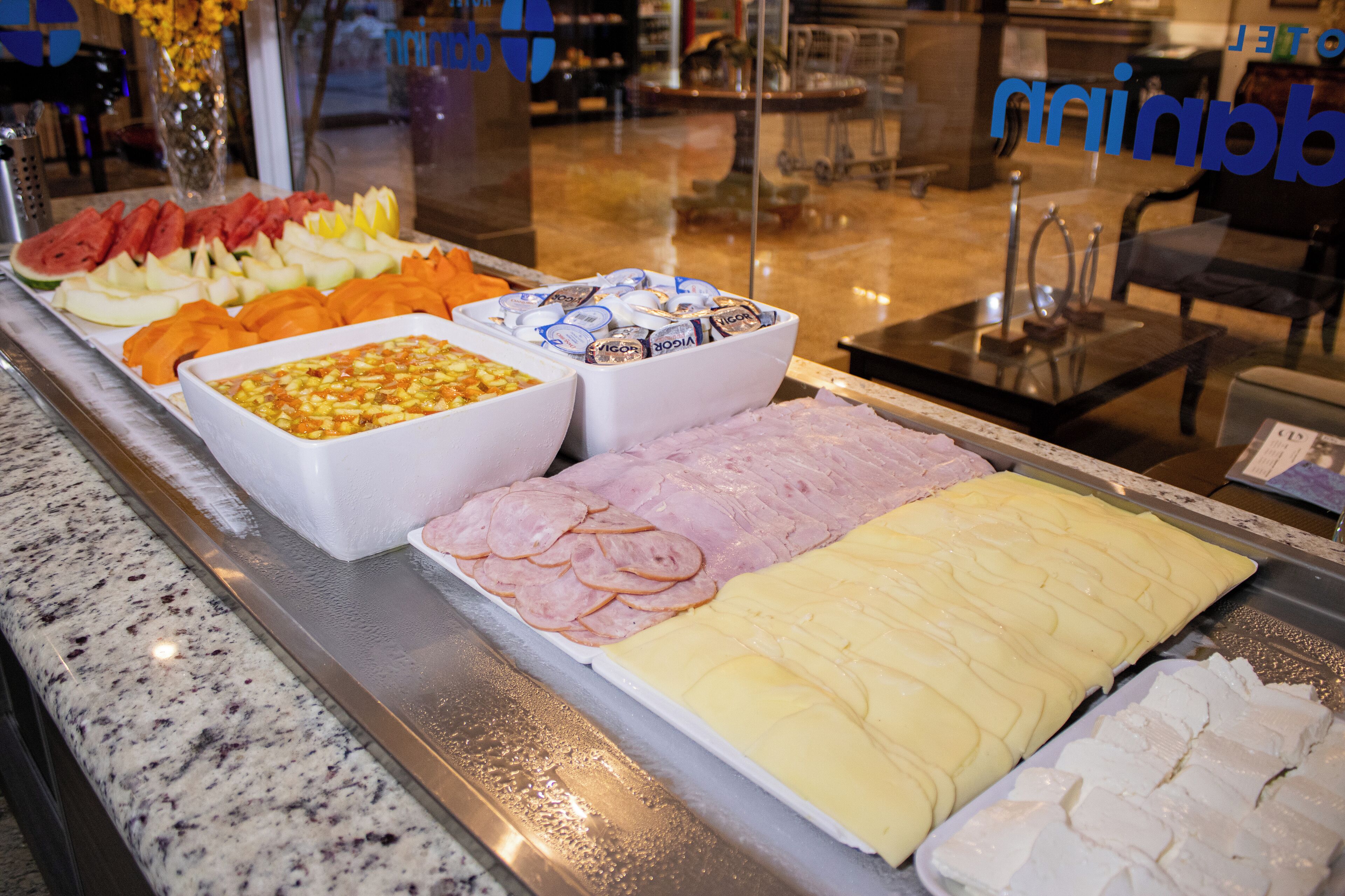 Un buffet proposant une variété de plats, notamment des fruits, des fromages et des viandes.