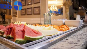 A buffet with various fruits and a hotel sign in the background. - Hotel Dan Inn Araraquara By Nacional Inn  (Araraquara)
