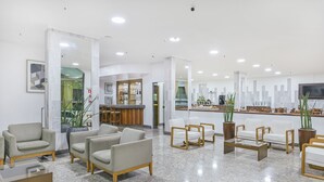 Un vestíbulo moderno con zonas de estar, un mostrador de recepción y un bar.