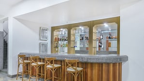 Un espacio de bar con taburetes de madera y encimera de granito.