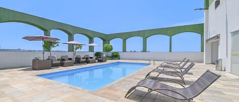 Piscine extérieure, parasols de plage, chaises longues