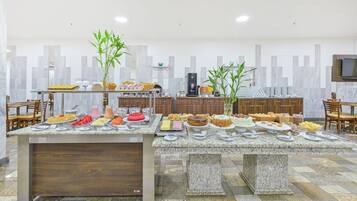 A buffet with various food items and a coffee station.
