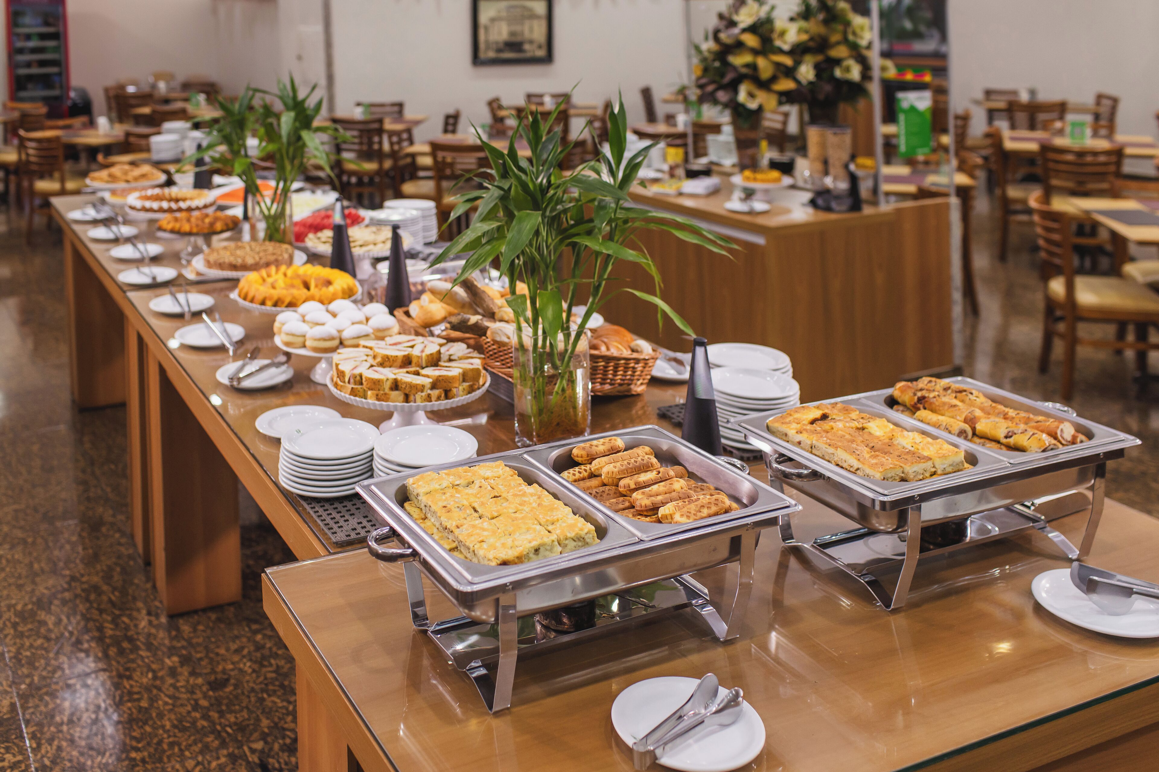 A buffet setup with various food items and a central plant.