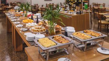 A buffet setup with various food items and a central plant.