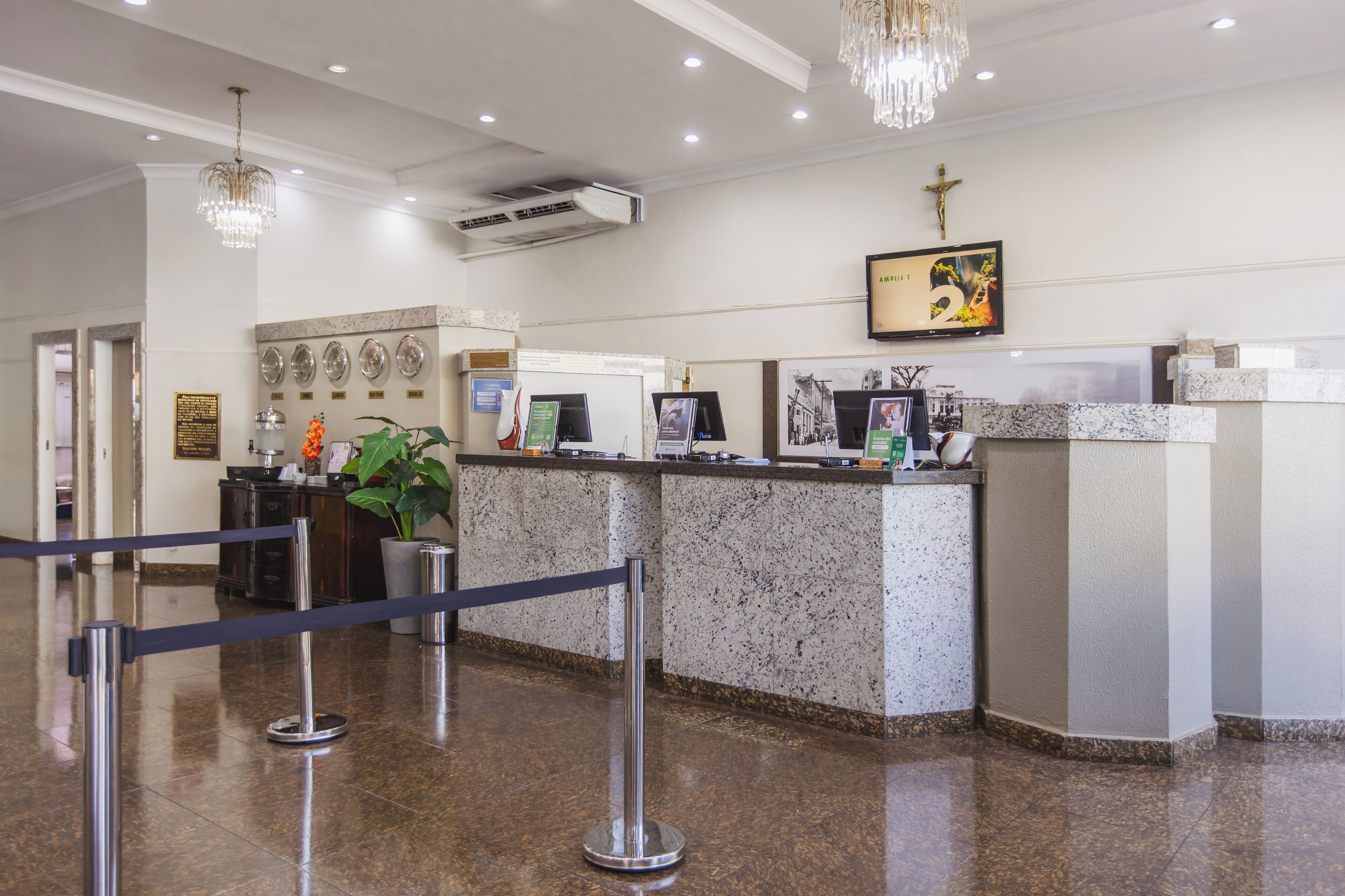 A reception area with a marble counter, a cross on the wall, and a chandelier.