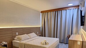 A hotel room with a bed, a bedside table with a phone, a small wooden desk, and a TV mounted on the wall. - Hotel Nacional Inn Ribeirão Preto (Ribeirão Preto)