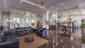 A spacious lobby with leather seating, a reception desk, and a kitchen area. - Hotel Nacional Inn Ribeirão Preto (Ribeirão Preto)