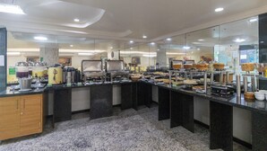 Un buffet avec différents stands de nourriture, un sol en marbre et un design de plafond moderne.
