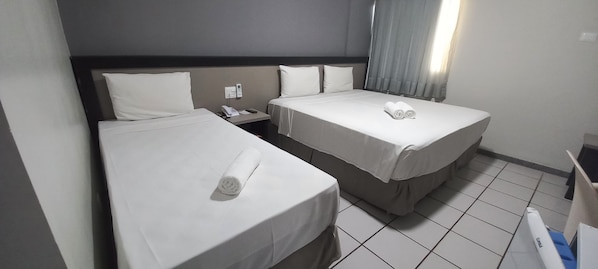 A hotel room with two single beds, a nightstand with a phone, and a window with curtains. - Hotel Nacional Inn Aeroporto Recife  (Recife)
