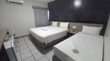 Habitación de hotel con dos camas, un escritorio y un teléfono.