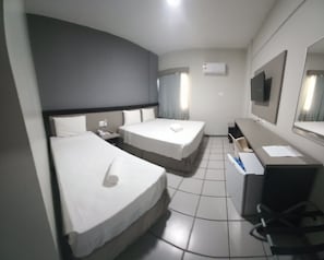 A hotel room with two beds, a desk with a chair, a TV, and an air conditioning unit. - Hotel Nacional Inn Aeroporto Recife  (Recife)