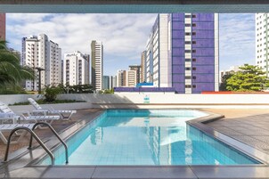 Una piscina con vistas a edificios altos en el fondo.