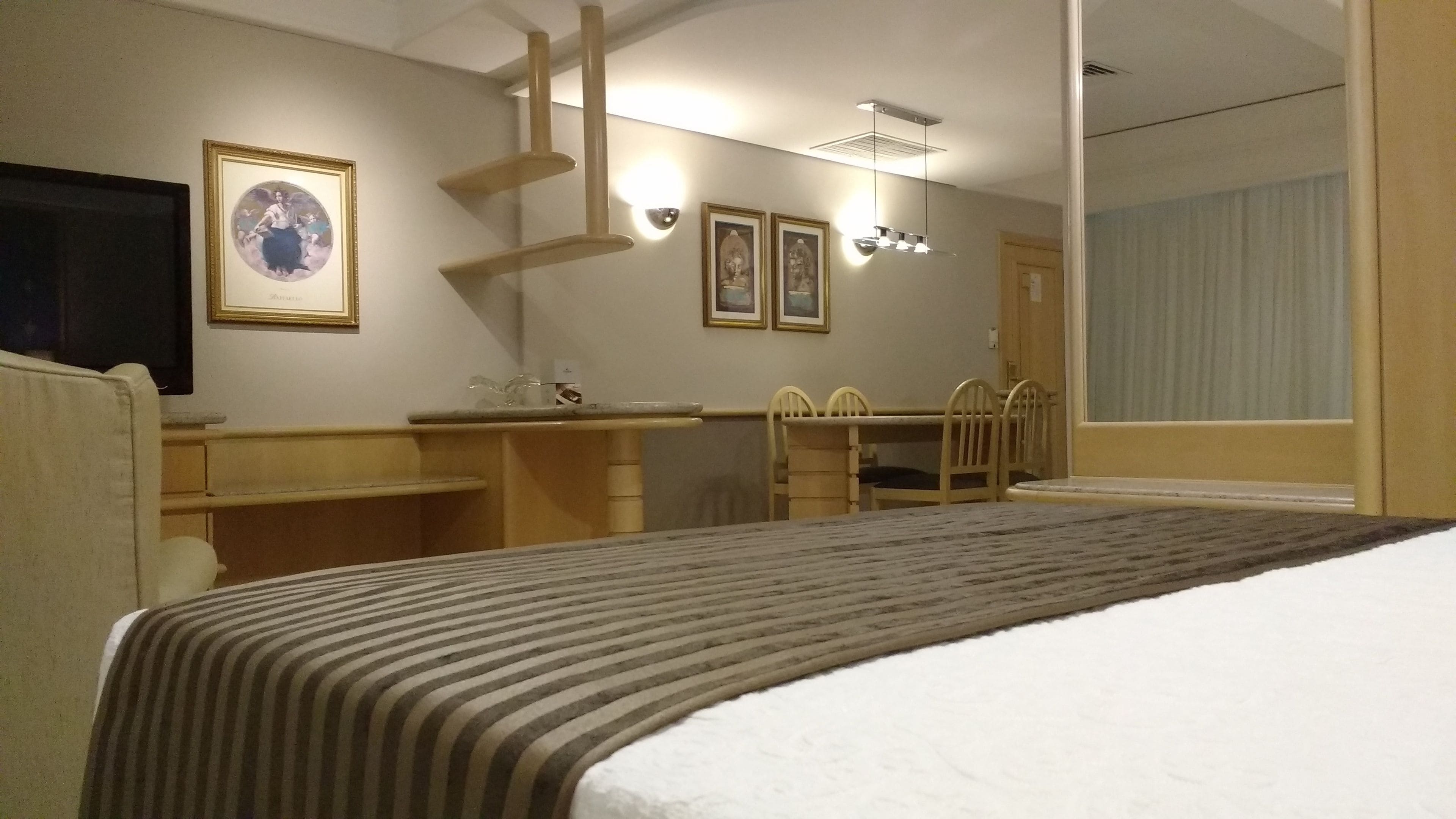 Une chambre d’hôtel équipée d’un lit, d’un bureau, d’une chaise et d’un téléviseur.