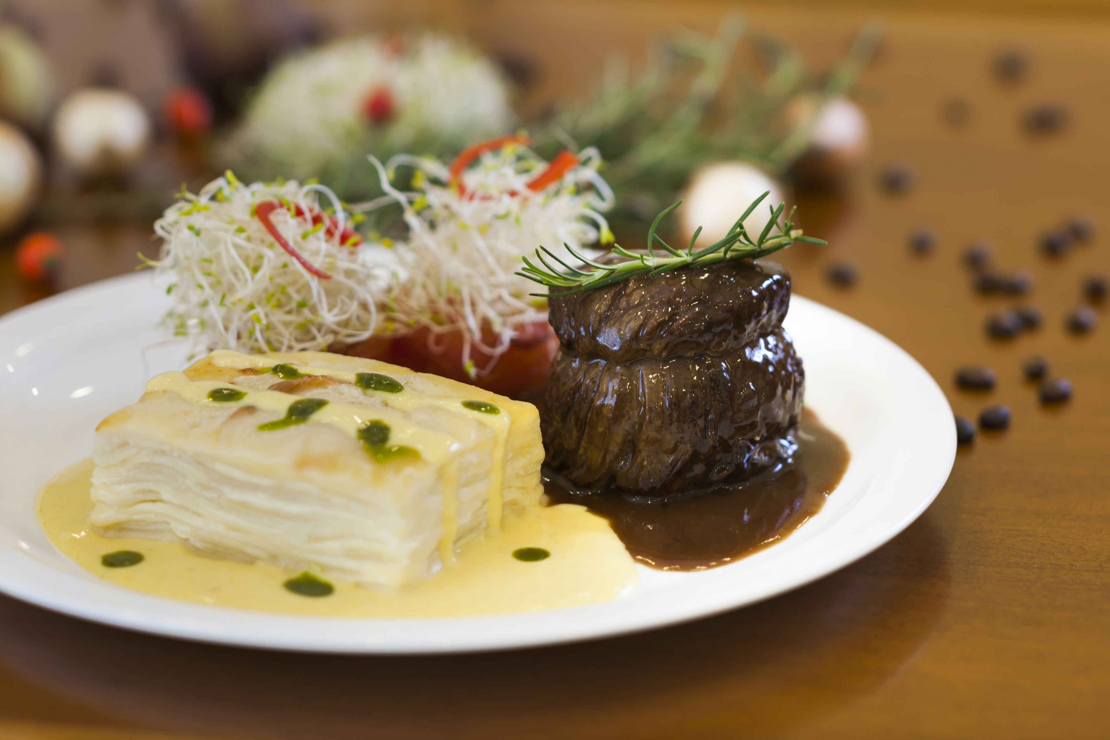 A plate of food with a piece of fish, a beef steak, and a side of vegetables.