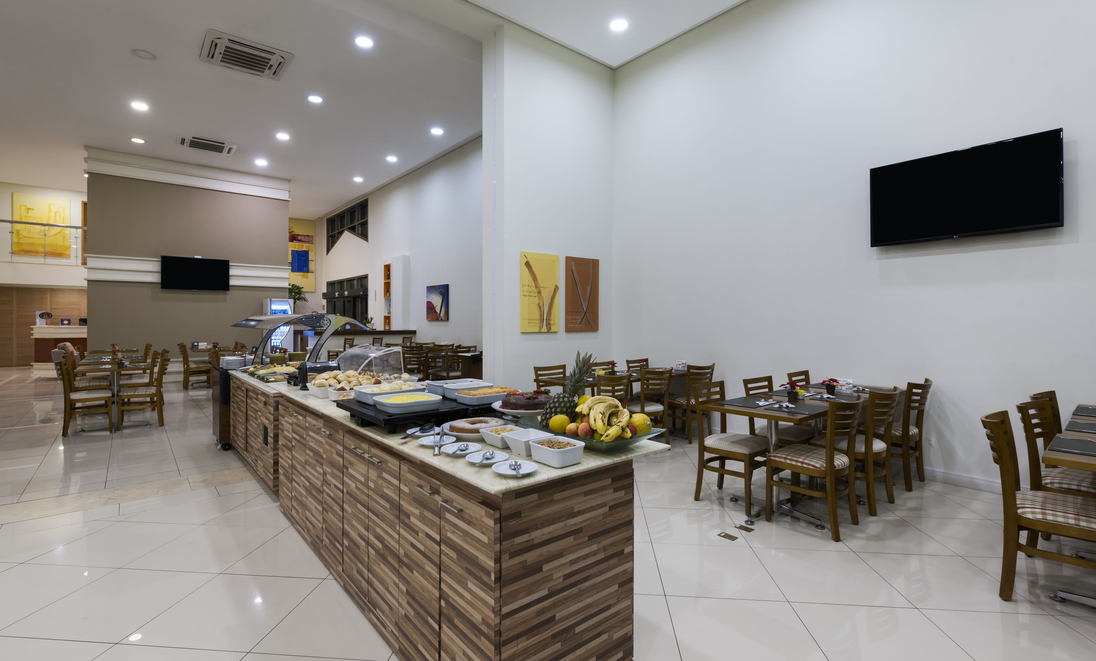 A buffet area with a variety of food items and a seating area with chairs and tables.